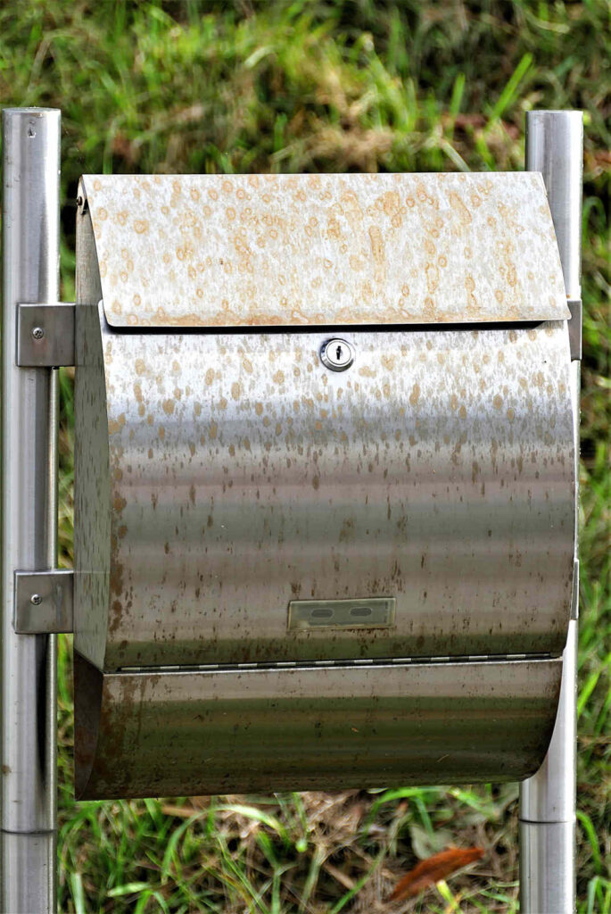 Eine Briefkastenanlage aus Edelstahl mit deutlich sichtbaren Flecken von Flugrost.